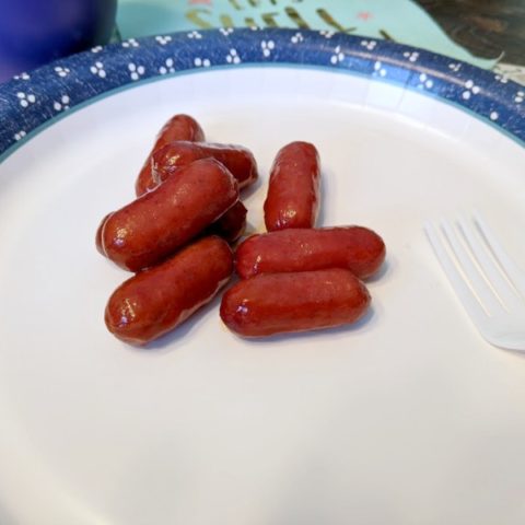 Cocktail wienies on paper plate.