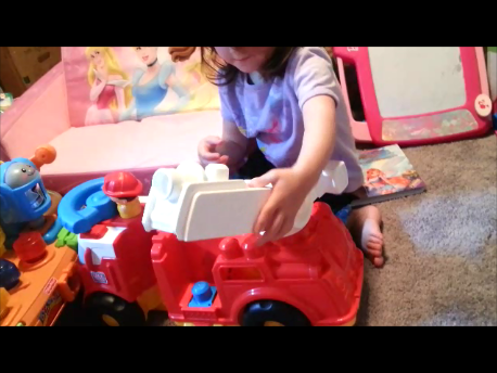 toddler playing with mega bloks firetruck