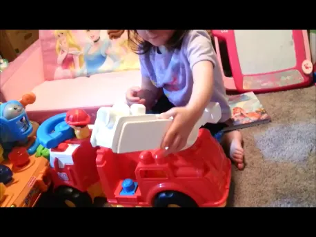 toddler playing with mega bloks firetruck