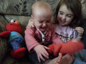 kids sitting on couch one crying