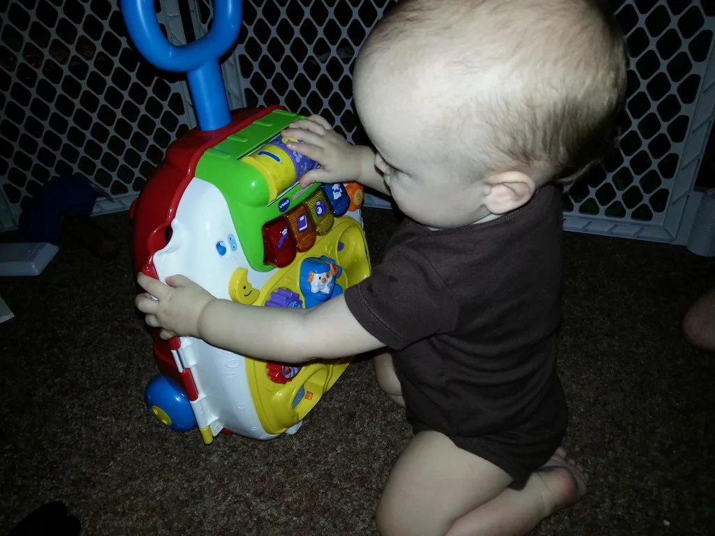 baby playing with vtech roll and learn suitcase