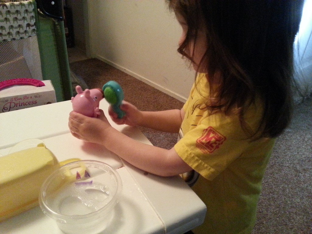 toddler playing with peppa pig toy