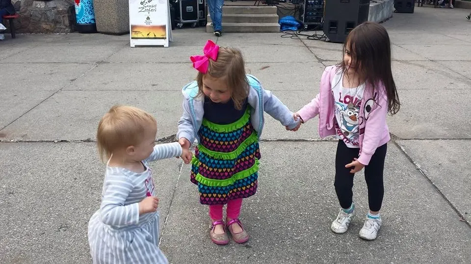 Little girls dancing together outside.