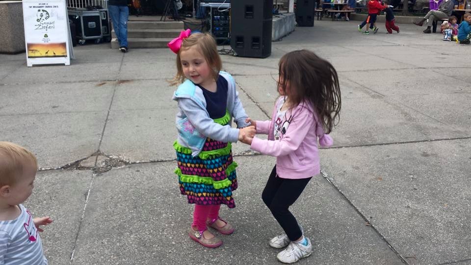 Two little girls dancing together.