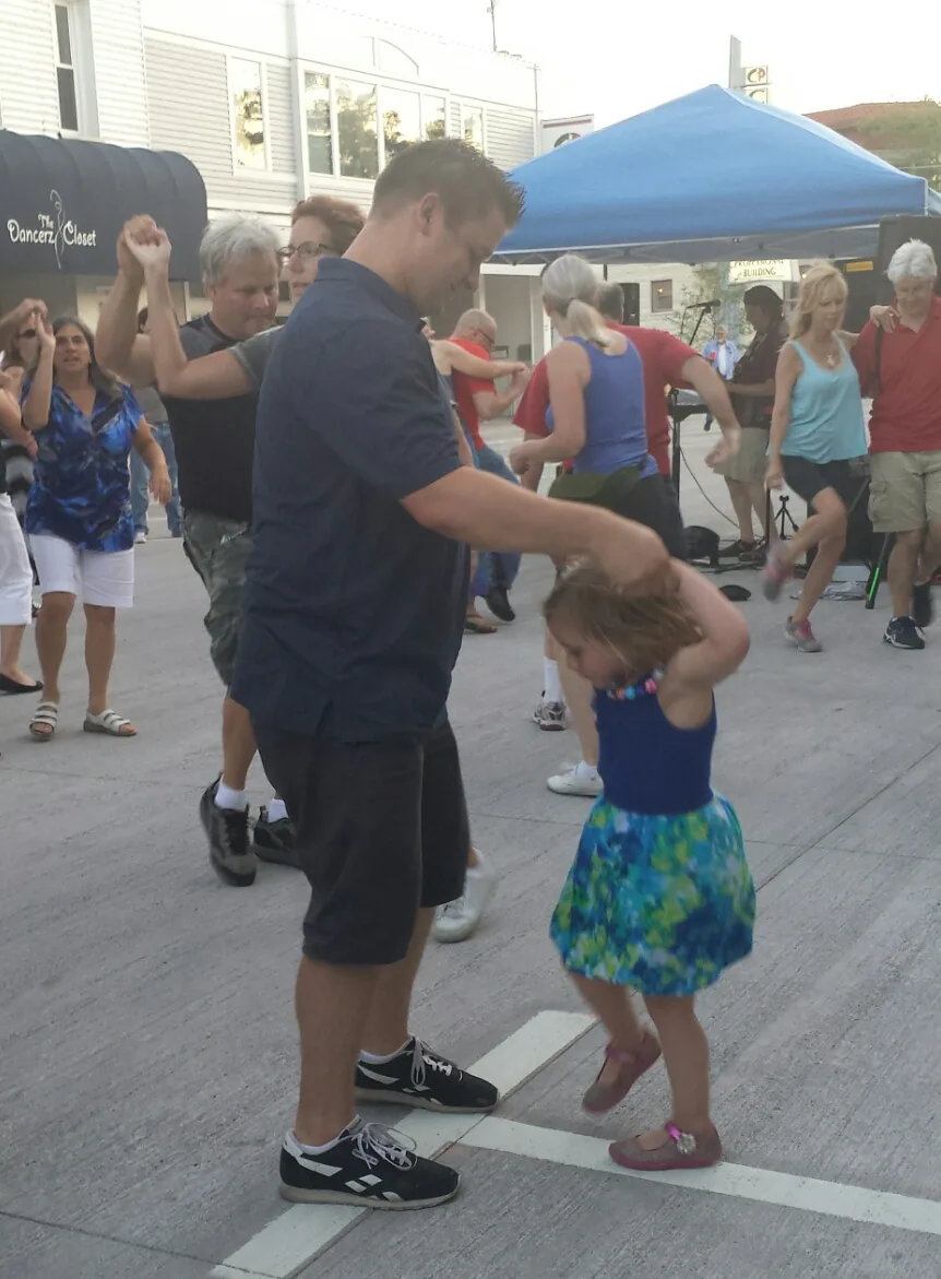 Daddy and daughter dancing in the street at Friday Night Live in Waukesha