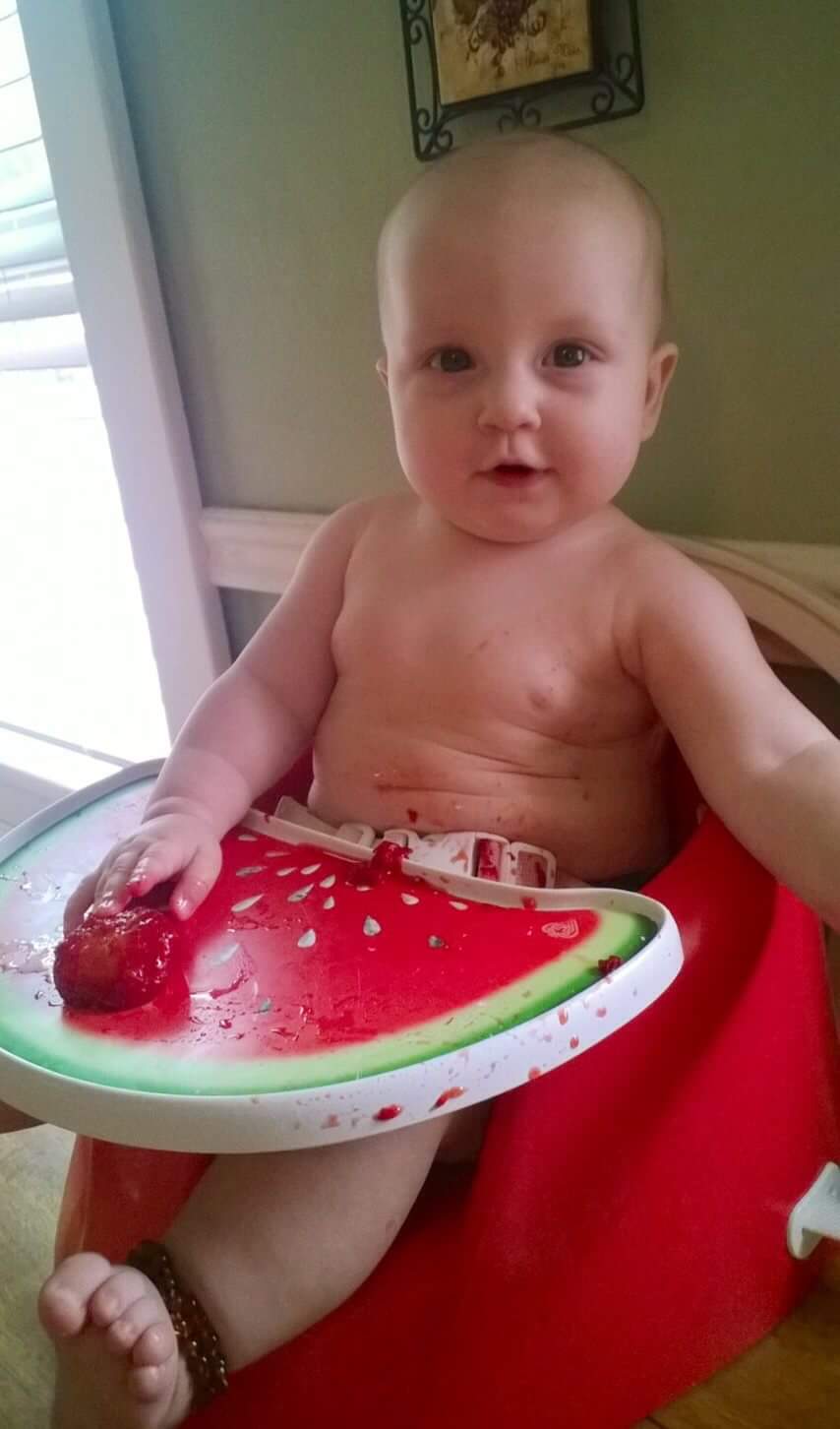 Baby eating in booster chair