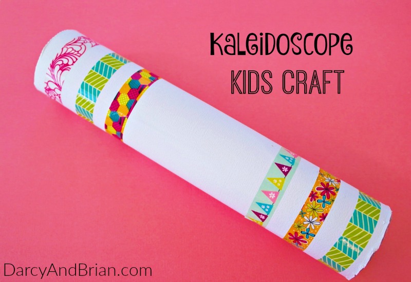 Paper towel tube decorated with paper and colorful washi tape laying on it's side at an angle on dark pink background. Black text in upper right says Kaleidoscope Kids Craft.