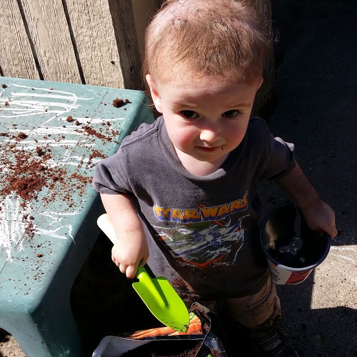 Toddler boy covered in dirt.