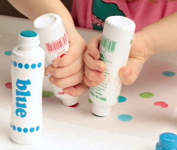 Child creating art with dot markers.