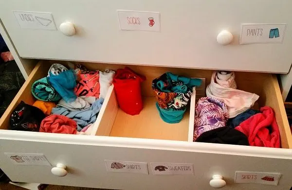 Open dresser drawer showing how using drawer labels and dividers help organize kids clothes.