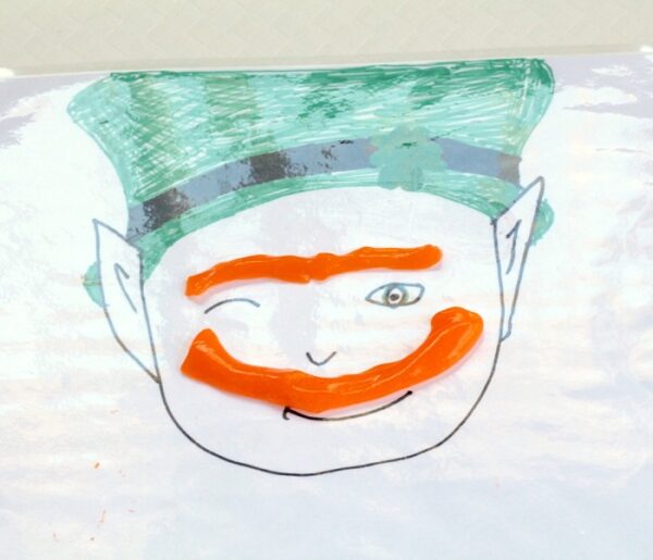 Leprechaun slime sensory play kids activity for St. Patrick's Day using slime to make mustache and eyebrow.