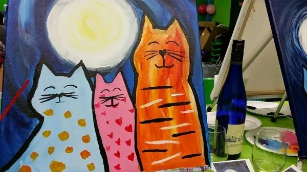 A canvas painting with cats during a wine and paint night activity.