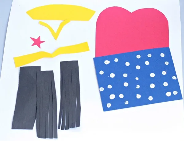 Pieces of construction paper cut to make a Wonder Woman's outfit and hair.