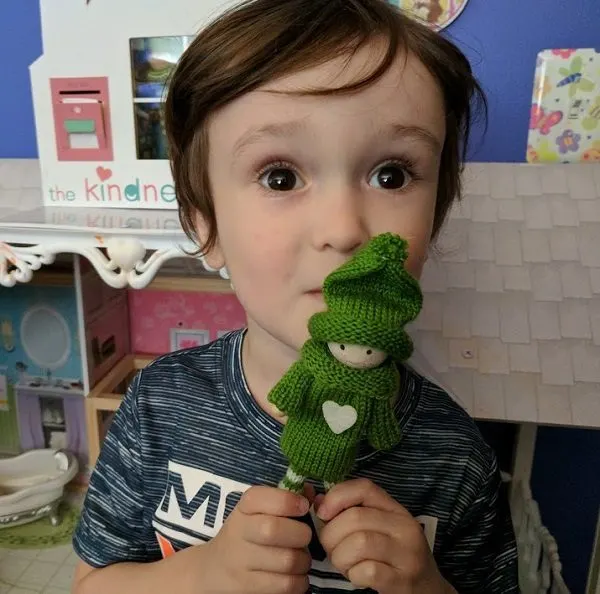 My son holding a green Kindness Elf.