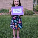 Girl holding first day of first grade printable photo sign