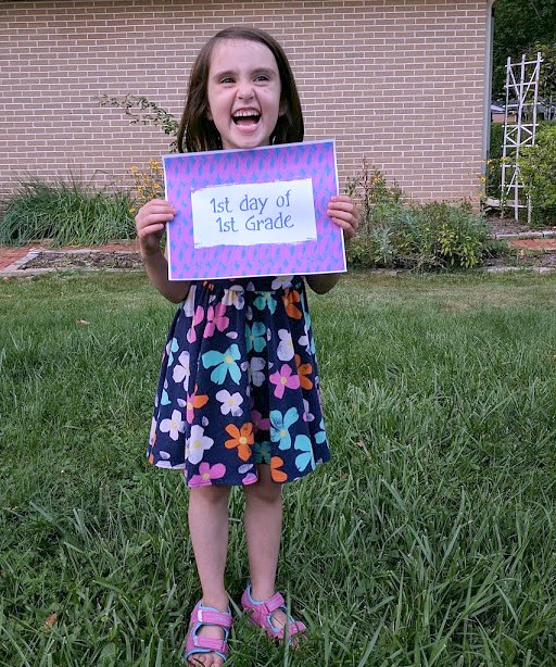 Girl holding first day of first grade printable photo sign
