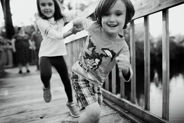 Author's children running on bridge in black and white photo