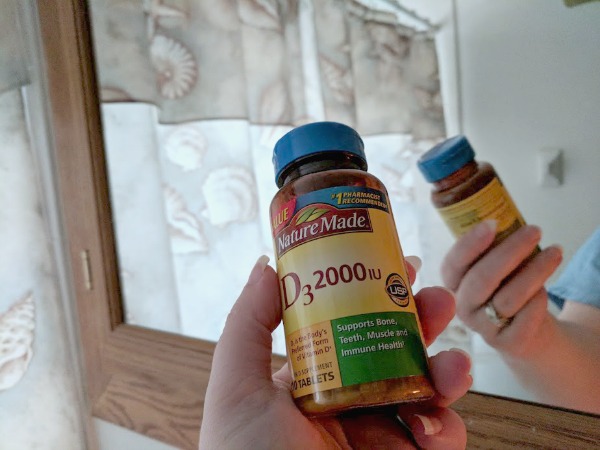 Taking vitamins out of medicine cabinet.