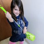 Author's daughter using kids mop as a guitar.