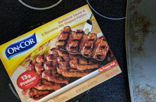 On-Cor Barbecue Sauce and Boneless Rib Shaped Patties package on top of stove.