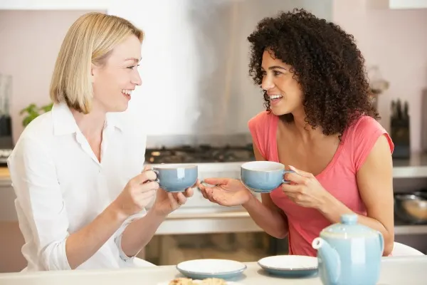 Two women having an openhearted conversation over a cup of tea.