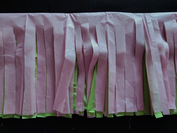 Cut strips in tissue paper for pom poms