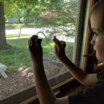 My son drawing on the window with chalk markers