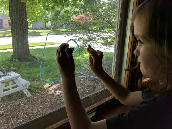 My son drawing on the window with chalk markers