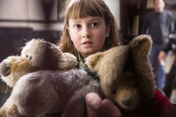 Little girl with Winnie the Pooh stuffed animals