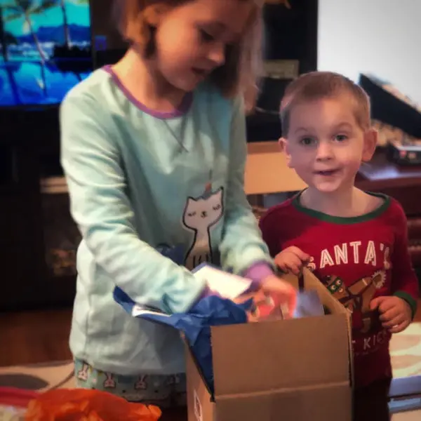 Two kids opening the Stay at Home Gamers Family Game Box.