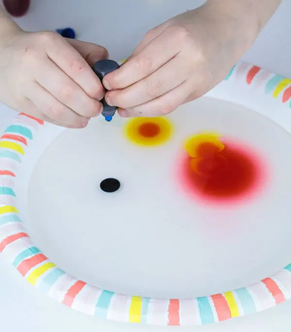 Kid adding food coloring for viscosity activity