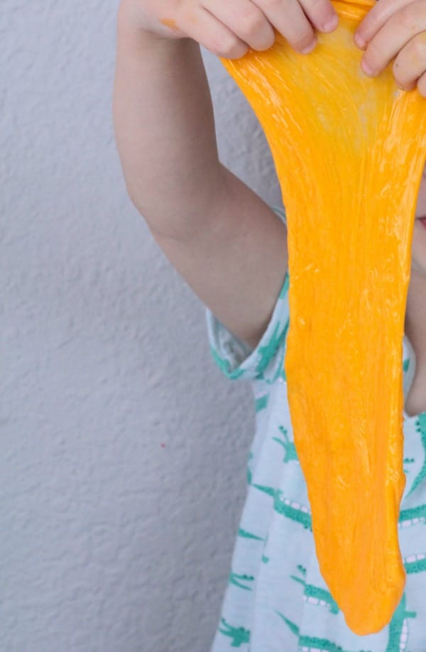 Kid holding slime as it stretches down