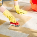 Person cleaning stain on carpet