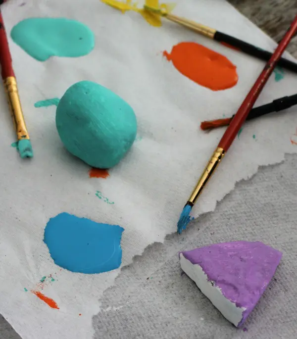 Rocks being painted blue and purple.