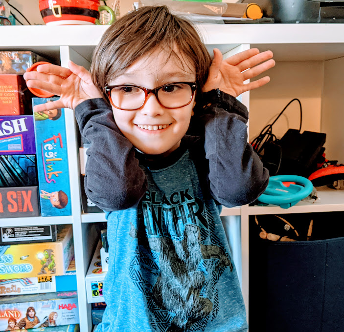 Author's son holding hands out from sides of his head like he has big ears.