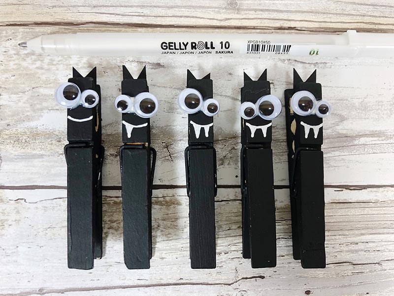 Five clothespins painted black with googly eyes for Halloween bat craft activity