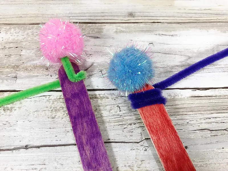 Wrapping pipe cleaners around popsicle craft sticks for project