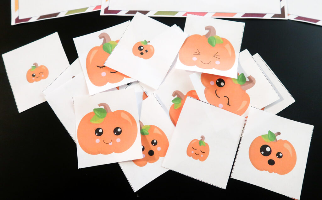 Close view of assorted cute pumpkin face cards. Pumpkins are different sizes.