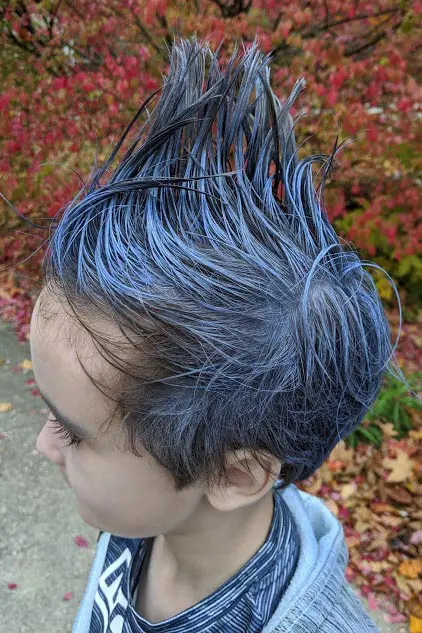 Close up side view of boy's head with spiked hair with white and blue hair coloring.