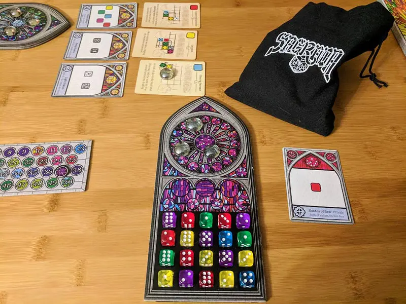 Sagrada dice game set up on table. Board is filled with dice.