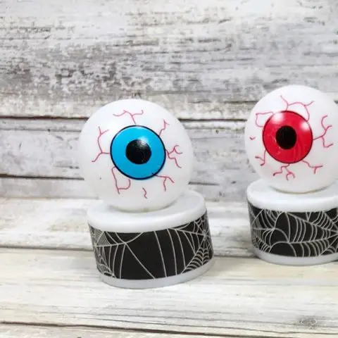 Two finished monster eyeball tea light crafts. One with blue iris and one with red iris.