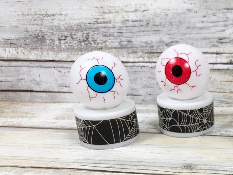 Two finished monster eyeball tea light crafts. One with blue iris and one with red iris.