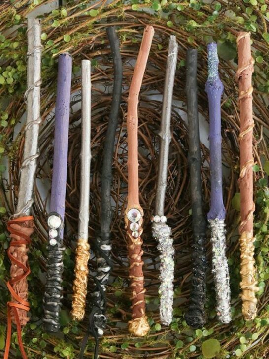 Completed set of homemade wands laying on a greenery.