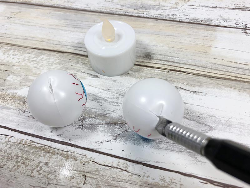 Using craft knife to cut ping pong ball for DIY project