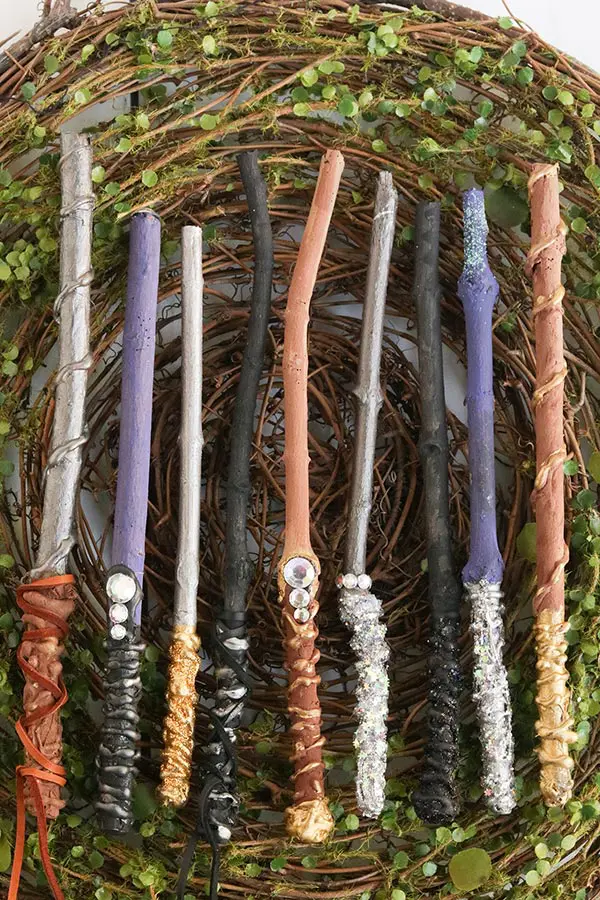 Completed set of homemade wands laying on a greenery.
