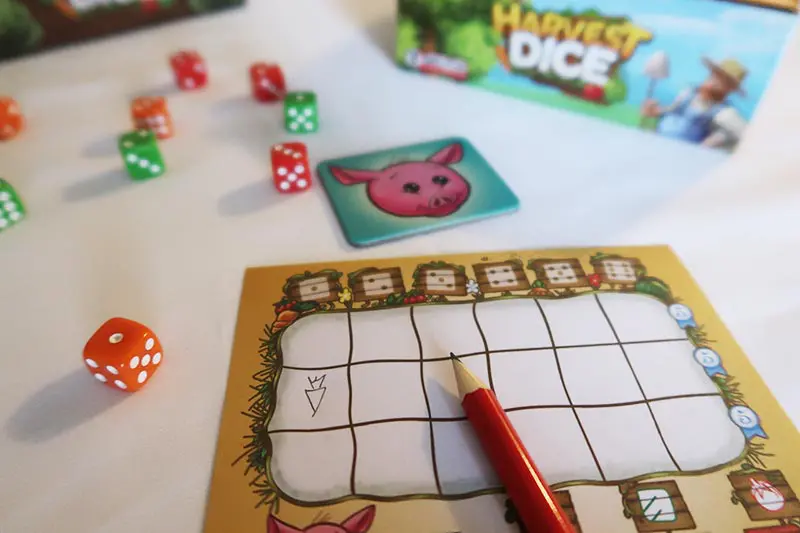 Harvest Dice game components on white table.