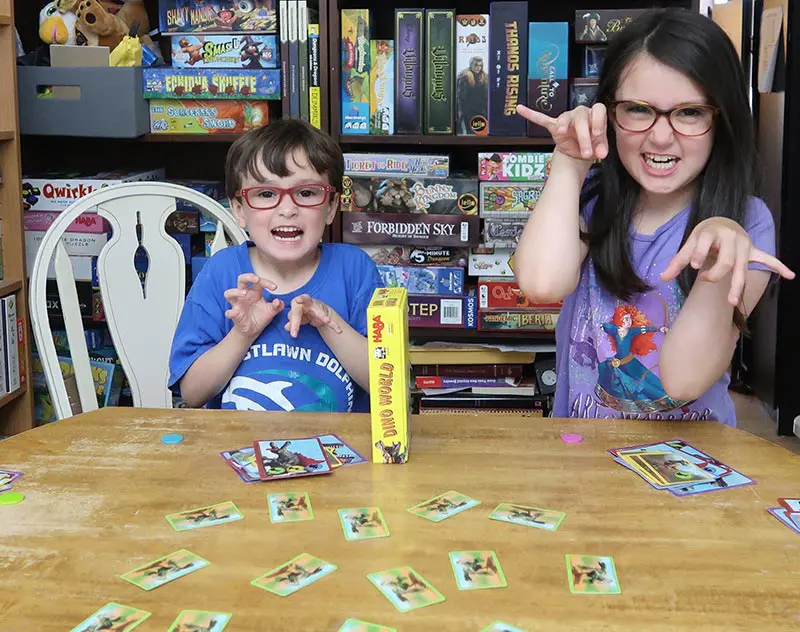 Author's son and daughter pretending to be dinosaurs while playing Dino World board game.