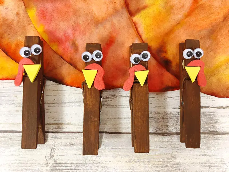 Close up of four clothespins decorated to look like turkeys.