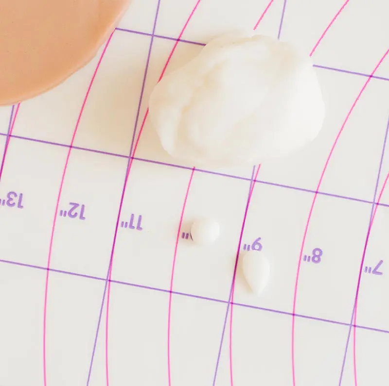 Shaping small pieces of white fondant into vampire fangs