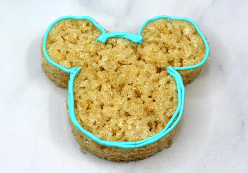 Mickey Mouse shaped rice crispy treat with blue icing outline.